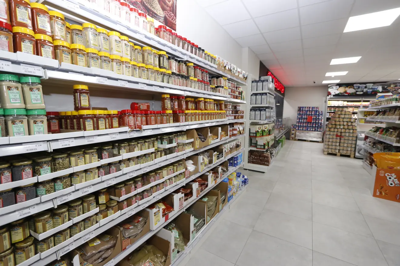 Komplette Regalwand mit Gewürzen und Kräutern in Gläsern, übersichtlich sortiert, bei Hayat Market