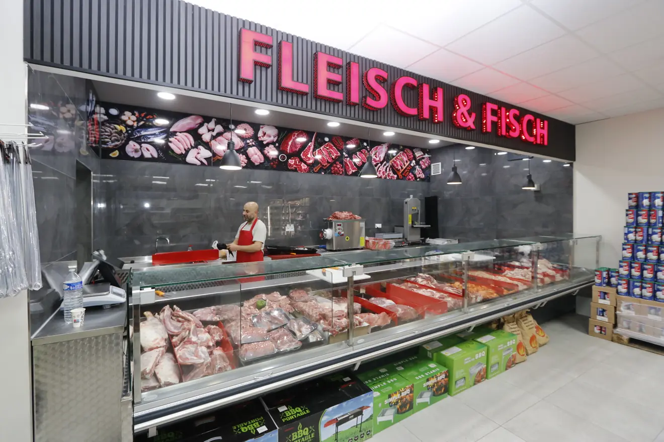 Bedientheke Fleisch und Fisch bei Hayat Market mit Metzger, frischem Fleisch in der Auslage und beleuchtetem Schriftzug Fleisch und Fisch